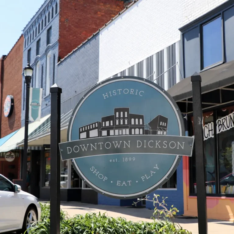 Historic Downtown Dickson Shop Eat Play sign in front of brick storefronts.