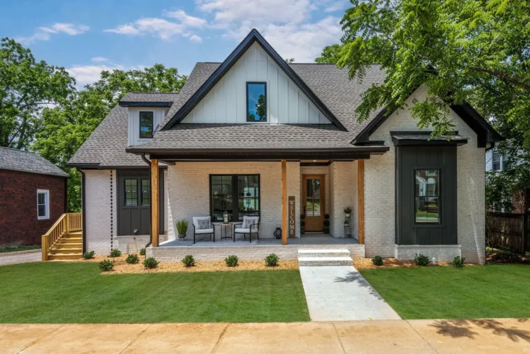 White brick home with a timber-post porch, front steps and a welcome sign.