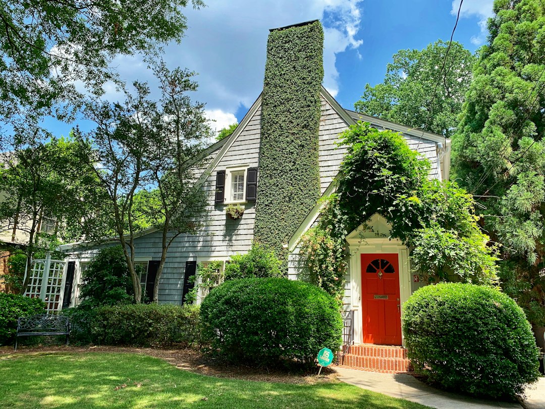 White Atlanta house with an ivy-covered chimney and red front door