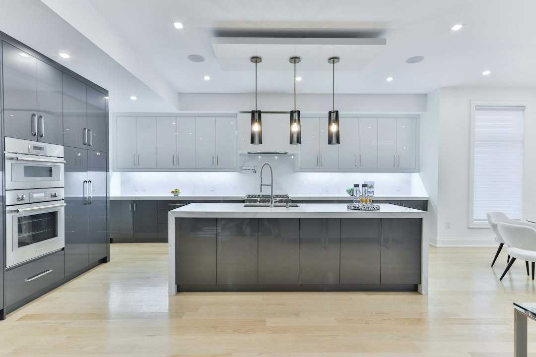 Bright kitchen with gray cabinetry and white island; illustrative stock photo