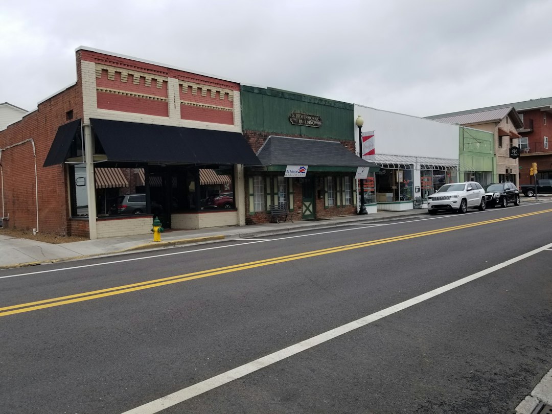Street with parked cars and storefronts; illustrative stock photo