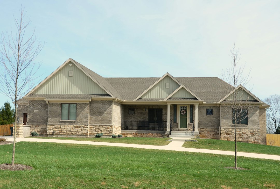 Light brick house with a covered entry and front lawn; illustrative stock photograph