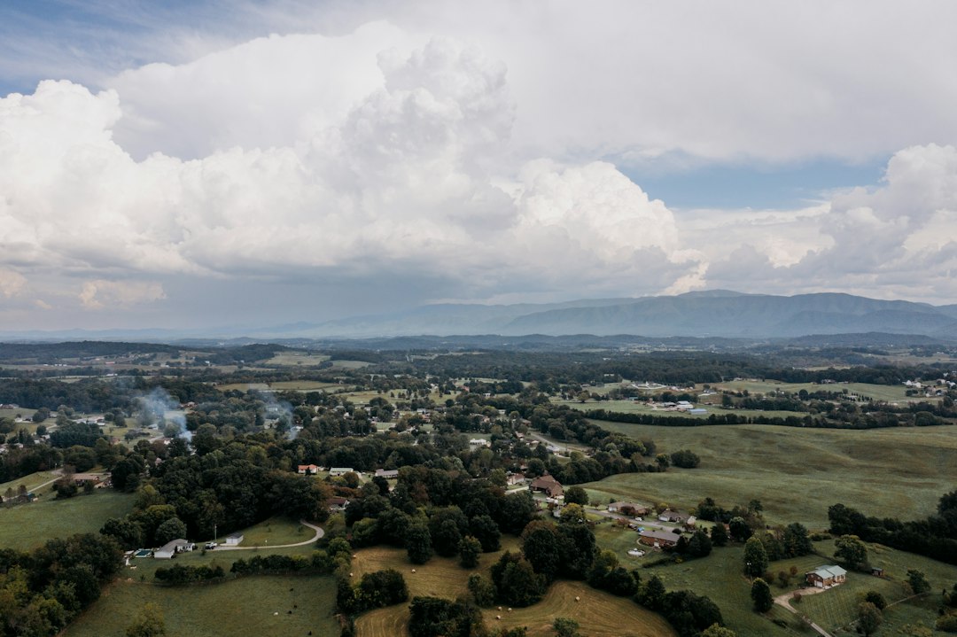 Aerial view of fields, scattered homes and wooded hills; illustrative stock photograph