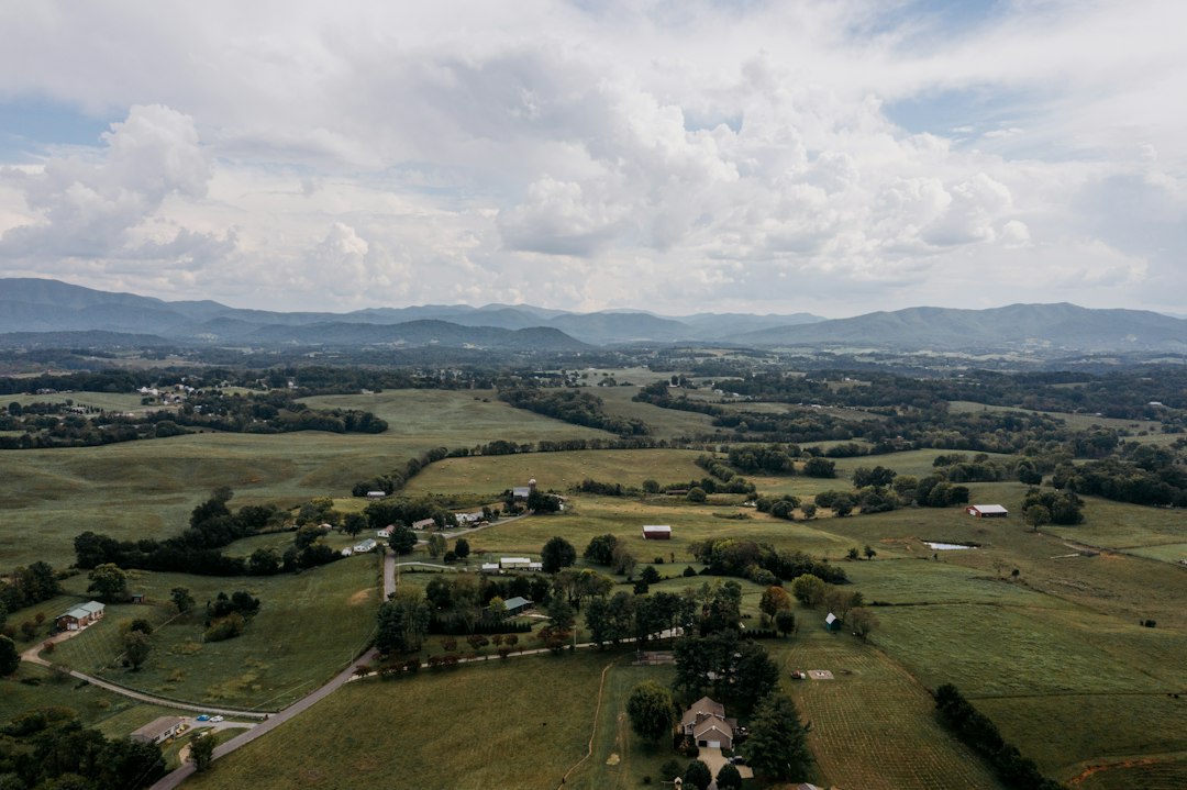 Green pasture, scattered houses and distant hills; illustrative stock photograph