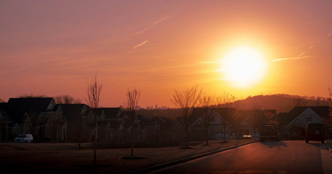 Sunset above a residential street and rooftops; illustrative stock photograph